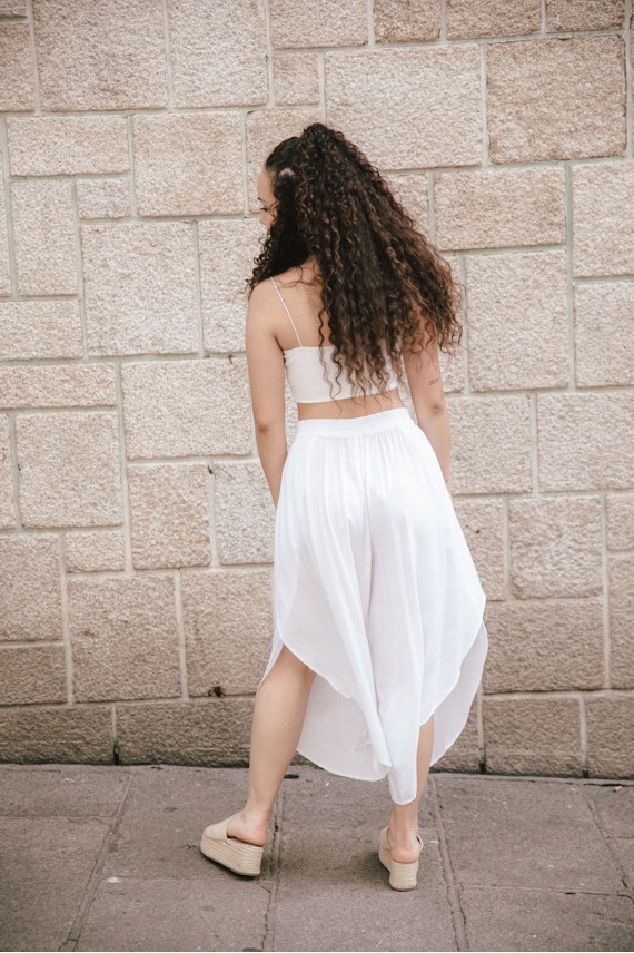 Pantalón Dhoti en viscosa abierto a modo de pareo en los laterales y ajustable a la cintura con goma en la parte de atrás.