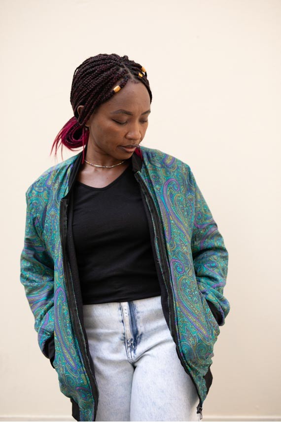Chaqueta bomber de seda paisley turquesa, azul y violeta con forro polar y acabados negros.