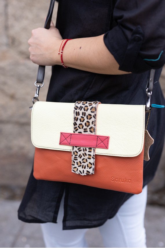 Bolso Soruka Lucía en piel sostenible, colores naranja y crema con lengüeta reversible de leopardo. Bolso Soruka Lucía en piel sostenible, colores naranja y crema con lengüeta reversible de leopardo.