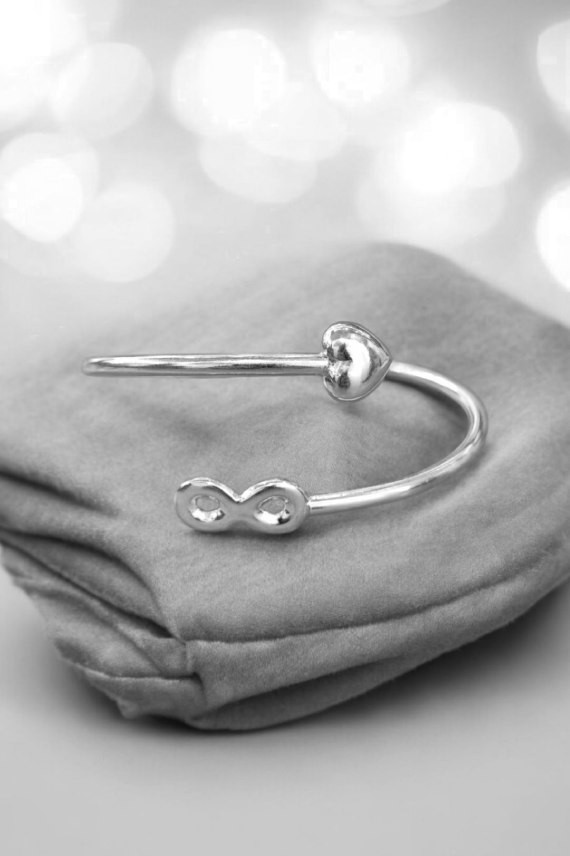 Pulsera de aro rígido en plata de ley con corazón e infinito en los extremos, símbolo de amor eterno. Pulsera de aro rígido en plata de ley con corazón e infinito en los extremos, símbolo de amor eterno.