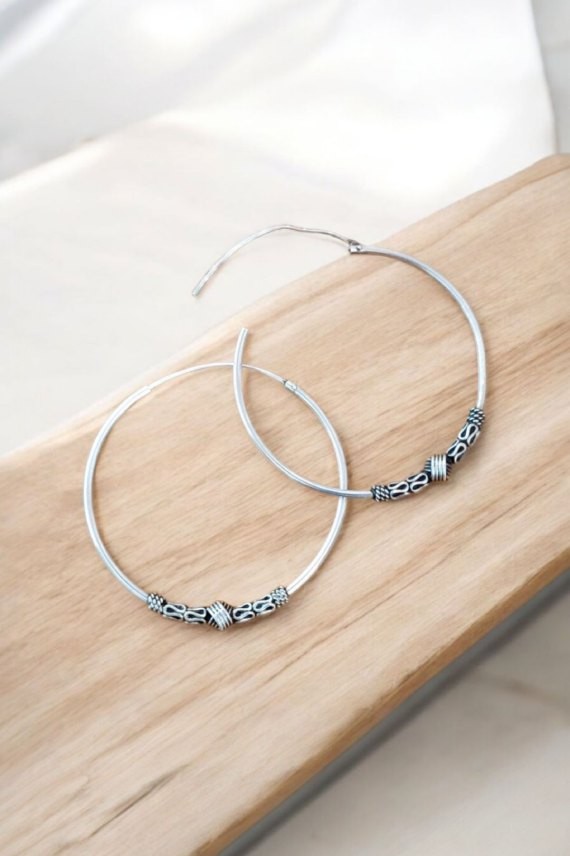 Aros de plata estilo bali con detalle de muelles y nudo central, cierre africano, diseño artesanal. Aros de plata estilo bali con detalle de muelles y nudo central, cierre africano, diseño artesanal.