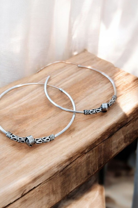 Aros de plata estilo bali con detalle de muelles y nudo central, cierre africano, diseño artesanal. Aros de plata estilo bali con detalle de muelles y nudo central, cierre africano, diseño artesanal.