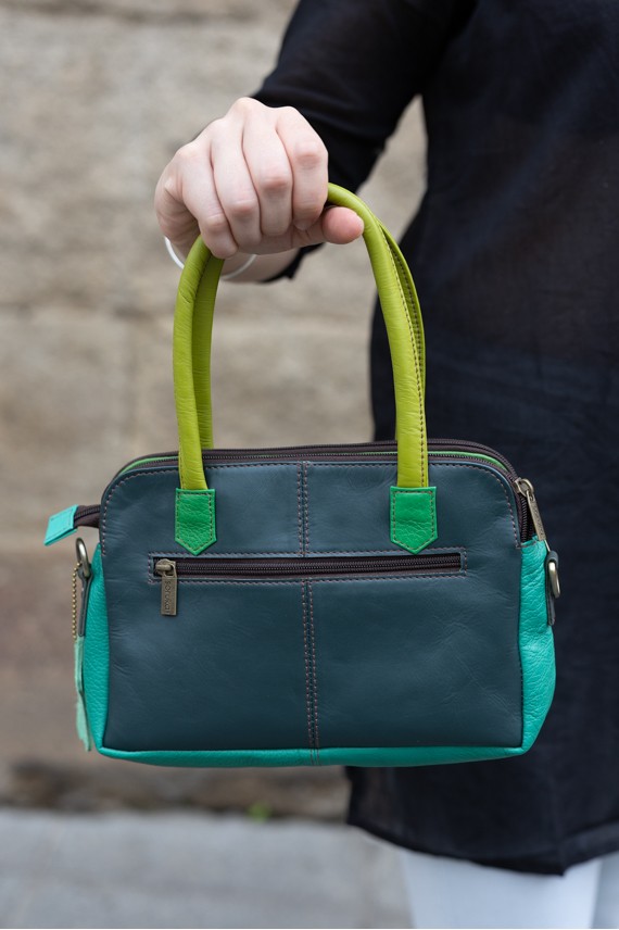 “Bolso Millie Soruka de piel reciclada con frontal de topitos, tres cremalleras y correa bandolera, artesanía sostenible.”