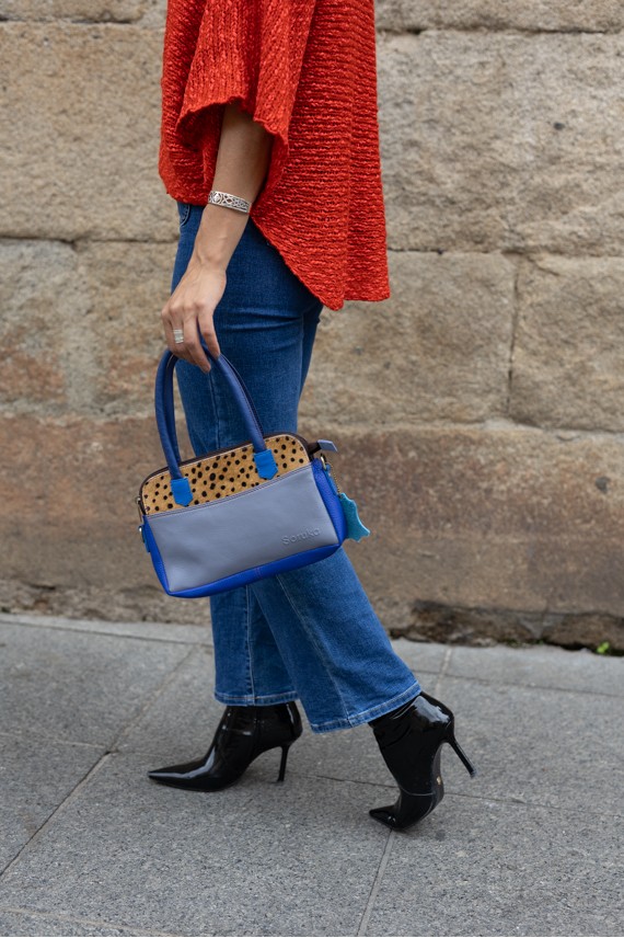 “Bolso Millie Soruka de piel reciclada con frontal de topitos, tres cremalleras y correa bandolera, artesanía sostenible.”