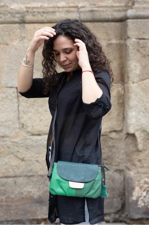 “Bolso Violet de piel reciclada Soruka con solapa reversible y asa con nudo ajustable, diseño artesanal sostenible.”