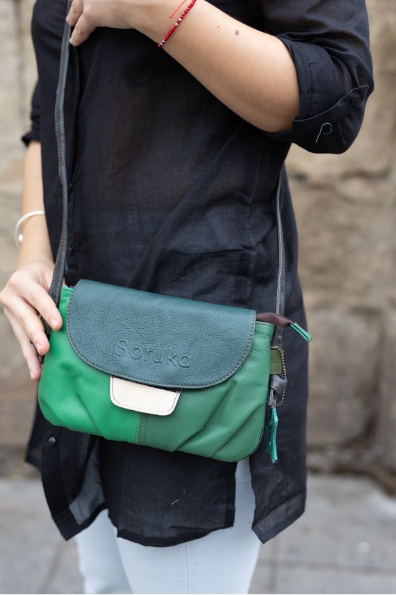 “Bolso Violet de piel reciclada Soruka con solapa reversible y asa con nudo ajustable, diseño artesanal sostenible.”