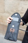 Bolso phone de piel negra con solapa banjara bordada y trenzado artesanal, diseño boho de Samarkanda.