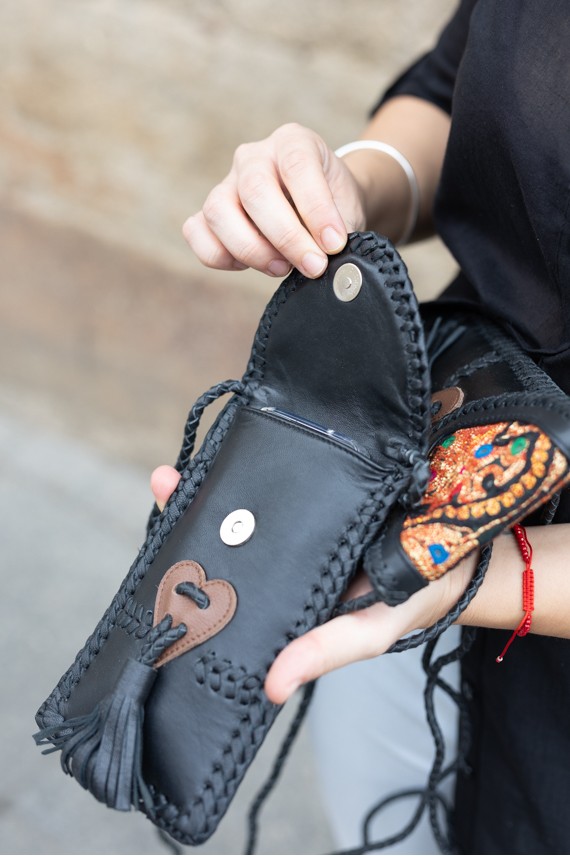 Bolso phone de piel negra con solapa banjara bordada y trenzado artesanal, diseño boho de Samarkanda.