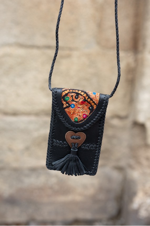 Bolso phone de piel negra con solapa banjara bordada y trenzado artesanal, diseño boho de Samarkanda.
