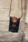 Bolso phone de piel negra con solapa banjara bordada y trenzado artesanal, diseño boho de Samarkanda.