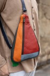 "Bolso bandolera unisex de piel sostenible Soruka en patchwork de tonos naranja, rojo y gris, diseño artesanal y ecológico