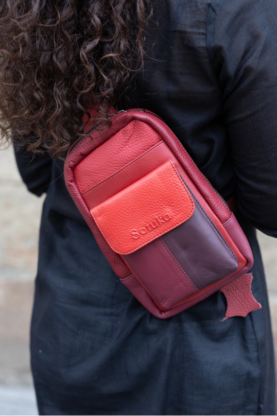 "Bolso bandolera Hailey Sling de piel sostenible Soruka con bolsillos frontales y diseño patchwork artesanal