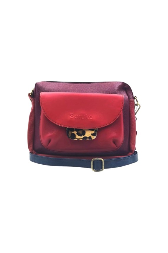 “Bolso Cher Soruka de piel reciclada en colores verde, azul y rojo, diseño artesanal sostenible con lengüeta reversible.”