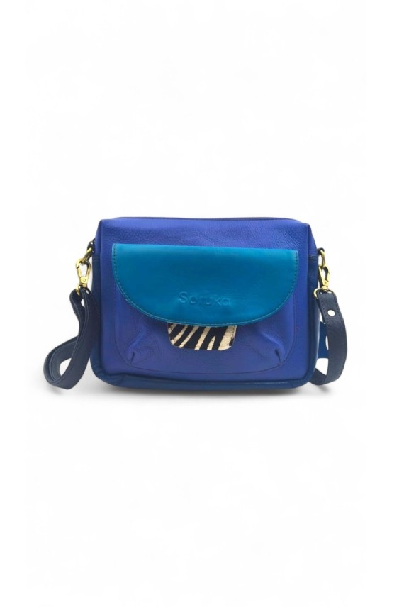 “Bolso Cher Soruka de piel reciclada en colores verde, azul y rojo, diseño artesanal sostenible con lengüeta reversible.”