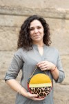 "Bolso Hera redondo de piel sostenible Soruka animal print de leopardo, en tonos mostaza, verde, beige y rojo.