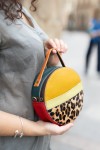 "Bolso Hera redondo de piel sostenible Soruka animal print de leopardo, en tonos mostaza, verde, beige y rojo.
