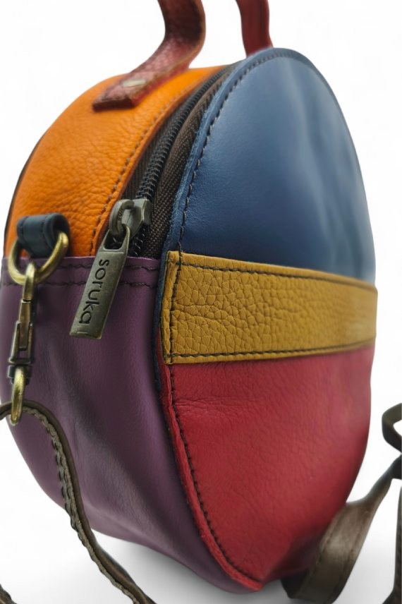 "Bolso Hera redondo multicolor de piel sostenible Soruka con tonos camel, rojo, azul y naranja,