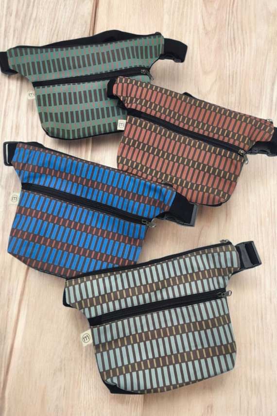 Riñonera de tela con estampado geométrico y doble cremallera, diseño moderno y práctico.