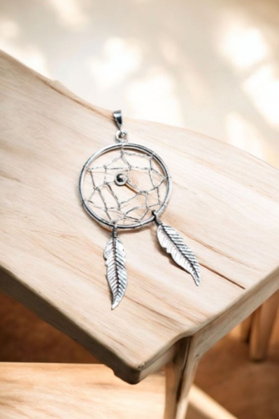 "Colgante de plata de ley con atrapasueños y dos plumas artesanales, diseño boho Samarkanda."