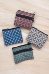 Monederos de tela con estampados geométricos en varios colores, cada uno con diseño compacto y doble cremallera.