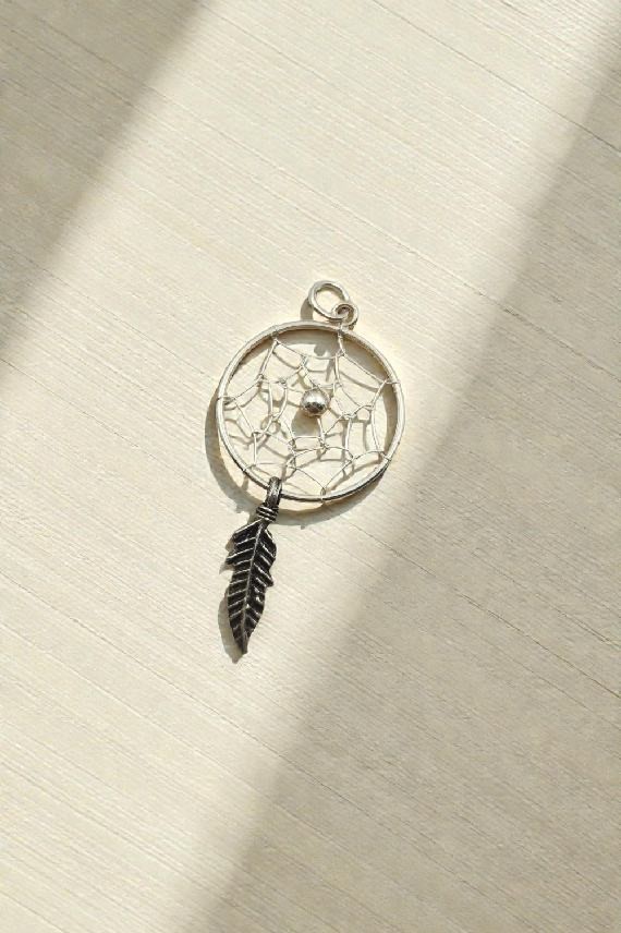 Colgante artesanal de plata con diseño de atrapasueños, red interior y una pluma colgante