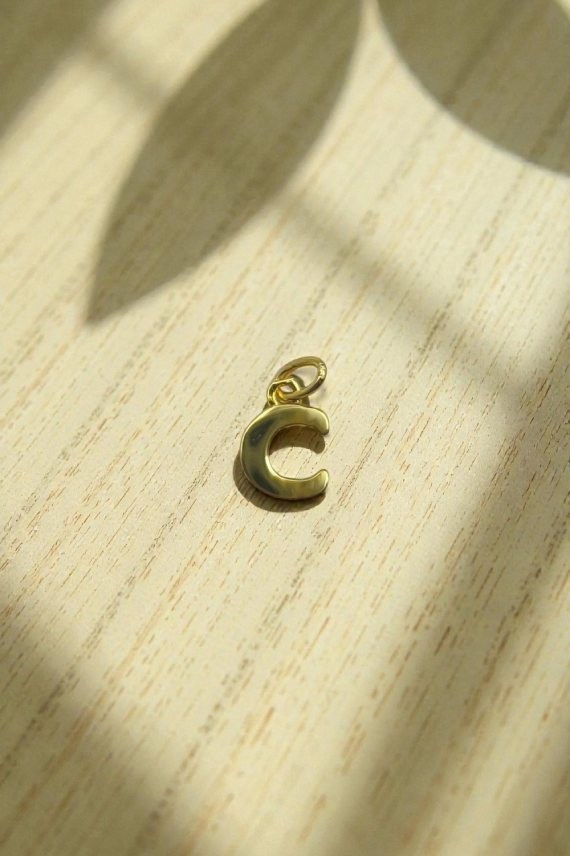 Colgante de plata con la letra C, diseño minimalista y acabado pulido dorado