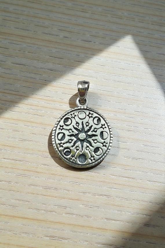 "Colgante de plata de ley 925 con fases lunares y sol central, diseño artesanal de 2 cm."