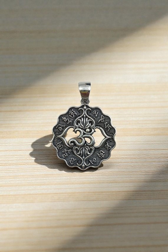 "Colgante de plata de ley 925 con símbolo Ohm y flor de loto, diseño circular artesanal de 3.2 cm."