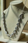 Collar de plata con diseño de hojas enlazadas y detalles brillantes