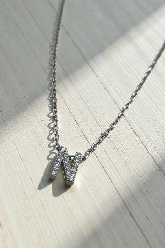 Collar de plata con colgante de inicial N decorada con detalles brillantes; disponible en acabado plateado y dorado.