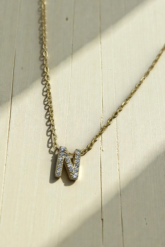 Collar de plata con colgante de inicial N decorada con detalles brillantes; disponible en acabado plateado y dorado.