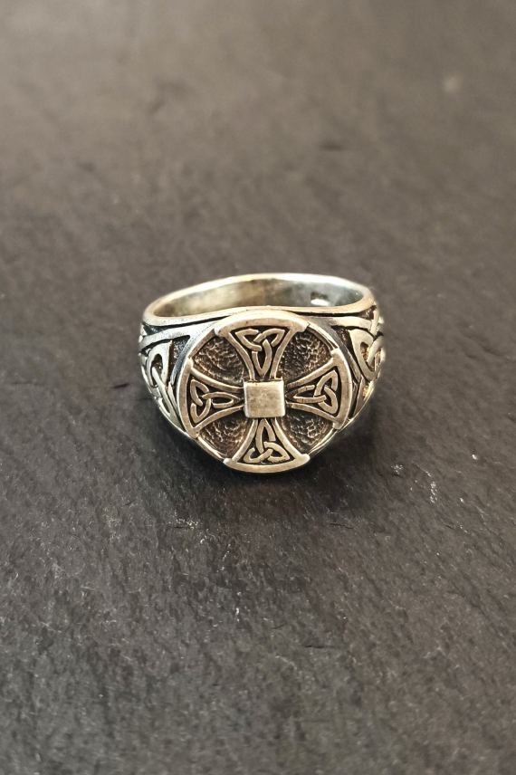 Anillo de plata con cruz celta en relieve y acabado envejecido, destacando sus grabados y diseño artesanal.