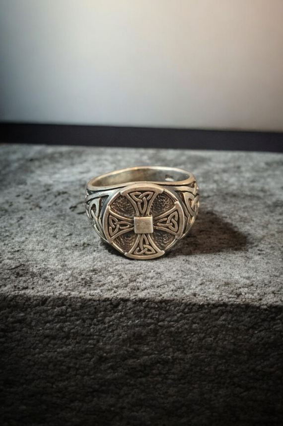 Anillo de plata con cruz celta en relieve y acabado envejecido, destacando sus grabados y diseño artesanal.