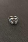Anillo plateado con cruz central y calaveras en relieve