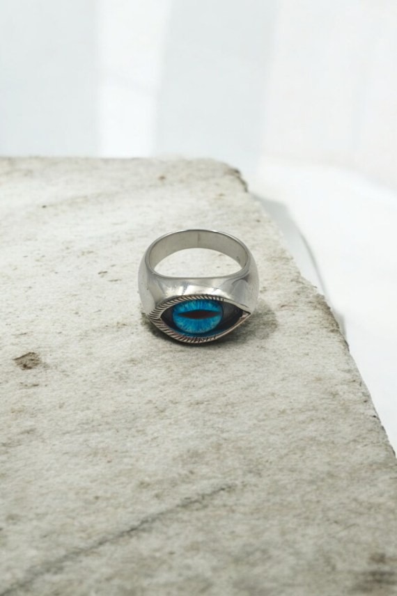 Anillo unisex de plata de ley con ojo decorativo central en color azul.
