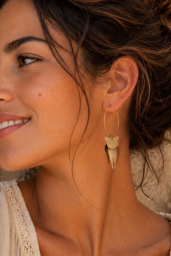 Pendientes de aro de acero con colgante de gato en latón, joya artesanal de estilo boho disponible en acabado dorado y plateado.