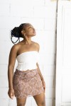 Falda corta estampada cachemira rosa con cinturón integrado y hebilla metálica, prenda boho chic para mujer.
