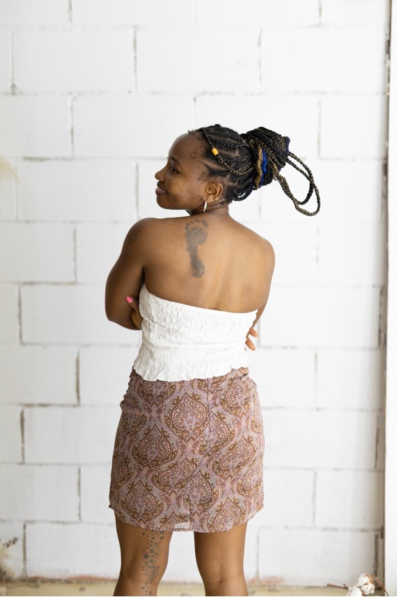 Falda corta estampada cachemira rosa con cinturón integrado y hebilla metálica, prenda boho chic para mujer.