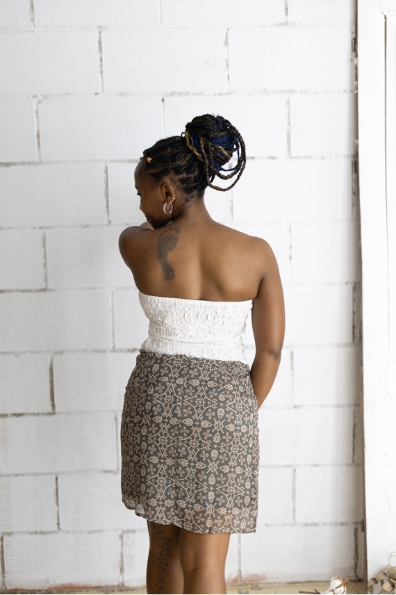 Falda corta gris con estampado floral beige y cinturón integrado con hebilla metálica, prenda boho chic para mujer.