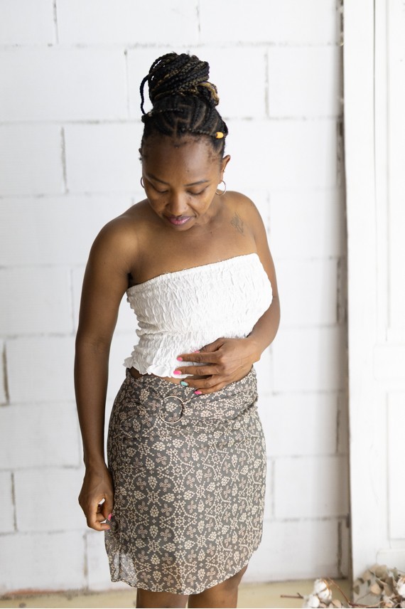 Falda corta gris con estampado floral beige y cinturón integrado con hebilla metálica, prenda boho chic para mujer.