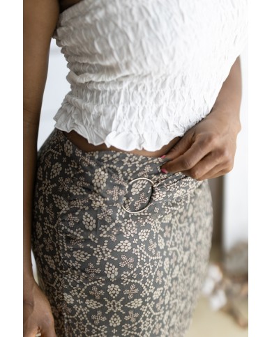 Falda corta gris con estampado floral beige y cinturón integrado con hebilla metálica, prenda boho chic para mujer.