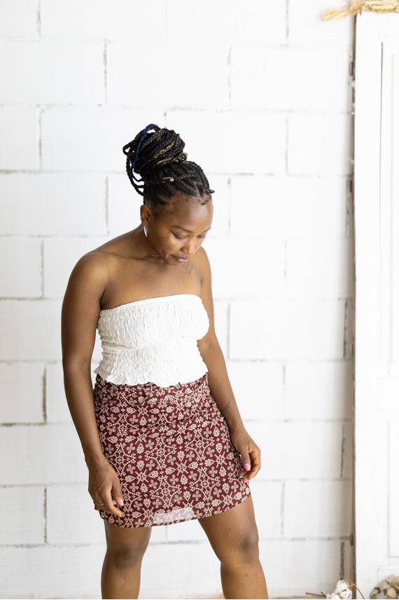 Falda corta burdeos con estampado floral beige y cinturón integrado con hebilla metálica, prenda boho chic para mujer.