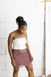Falda corta burdeos con estampado floral beige y cinturón integrado con hebilla metálica, prenda boho chic para mujer.
