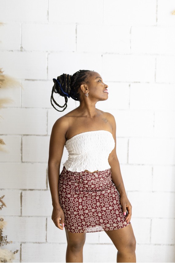 Falda corta burdeos con estampado floral beige y cinturón integrado con hebilla metálica, prenda boho chic para mujer.