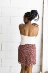Falda corta burdeos con estampado floral beige y cinturón integrado con hebilla metálica, prenda boho chic para mujer.