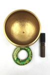 Cuenco tibetano artesanal de latón con mazo de madera y cojín decorativo para meditación, yoga y relajación.