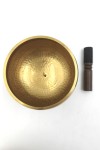 Cuenco tibetano artesanal de latón con mazo de madera y cojín decorativo para meditación, yoga y relajación.