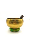 Cuenco tibetano artesanal de latón con mazo de madera y cojín decorativo para meditación, yoga y relajación.