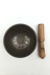Cuenco tibetano artesanal con símbolo Om Mani, mantras grabados, mazo de madera y cojín decorativo para meditación y relajación.
