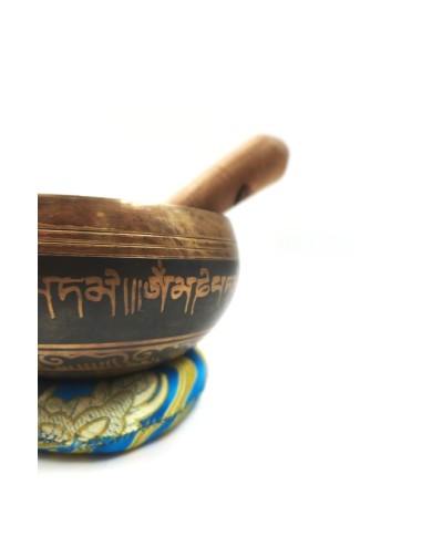 Cuenco tibetano artesanal con símbolo Om Mani, mantras grabados, mazo de madera y cojín decorativo para meditación y relajación.